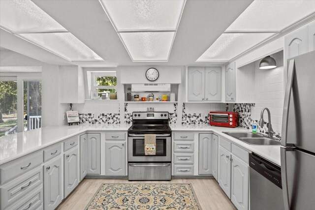315 Highlander Hts, Hideaway, TX 75771 - kitchen with light wood finished floors, exhaust hood, a sink, decorative backsplash, and appliances with stainless steel finishes