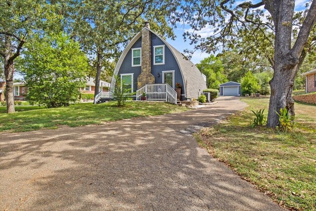 315 Highlander Hts, Hideaway, TX 75771 - a-frame style home with a chimney, aphalt driveway, an outdoor structure, a front yard, and a garage