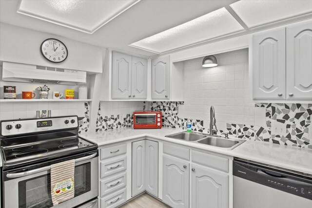 315 Highlander Hts, Hideaway, TX 75771 - kitchen with decorative backsplash, appliances with stainless steel finishes, a sink, and white cabinetry