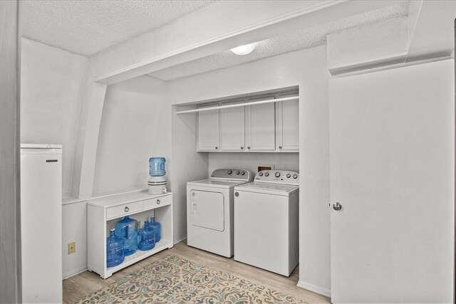 315 Highlander Hts, Hideaway, TX 75771 - clothes washing area featuring separate washer and dryer, cabinet space, a textured ceiling, and light wood finished floors