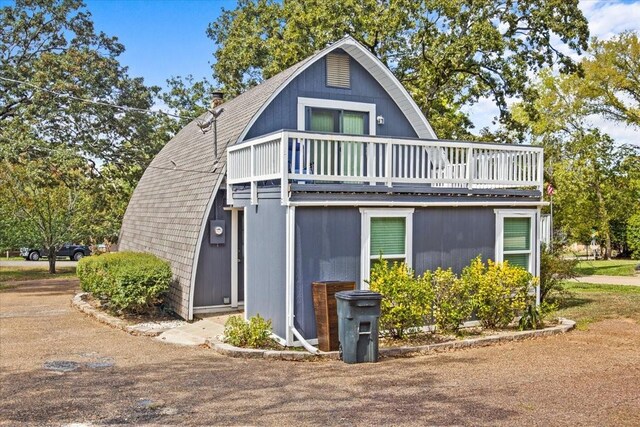 315 Highlander Hts, Hideaway, TX 75771 - view of side of property with a chimney, a wooden deck, a gambrel roof, and a shingled roof