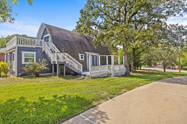 315 Highlander Hts, Hideaway, TX 75771 - exterior space with stairway, a gambrel roof, a shingled roof, a yard, and a wooden deck