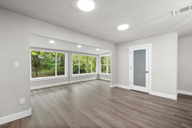 spare room featuring recessed lighting, visible vents, wood finished floors, and baseboards