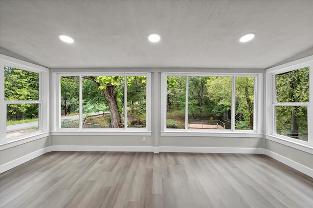 unfurnished sunroom featuring plenty of natural light, recessed lighting, and baseboards