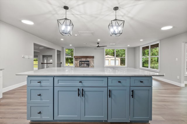 kitchen with light wood finished floors, recessed lighting, ceiling fan, decorative light fixtures, and baseboards