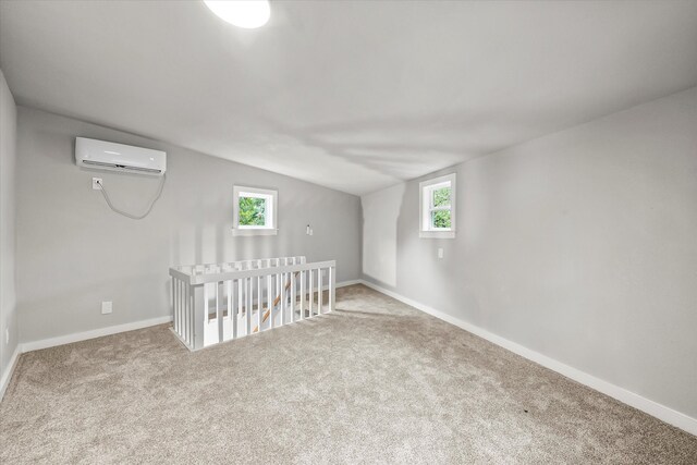 bonus room with a healthy amount of sunlight, carpet, and a wall mounted AC