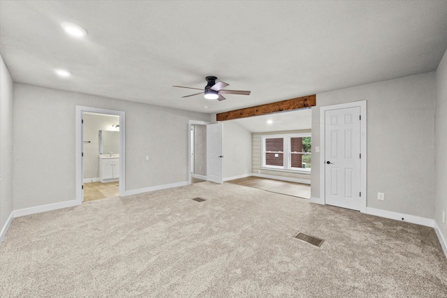 unfurnished living room with beam ceiling, light carpet, ceiling fan, and sink