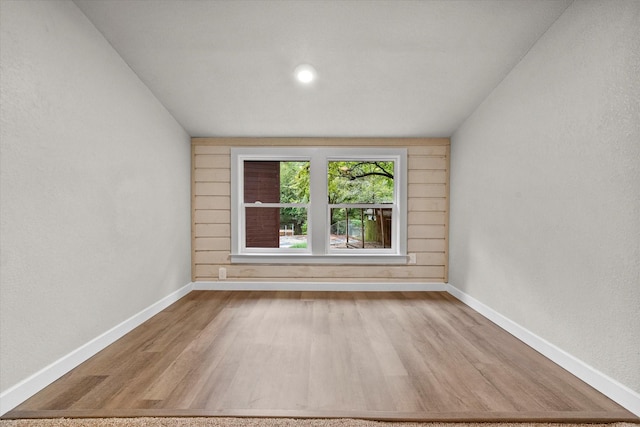 spare room with baseboards and wood finished floors