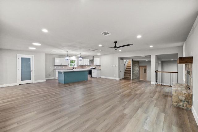 unfurnished living room with visible vents, recessed lighting, stairs, and baseboards