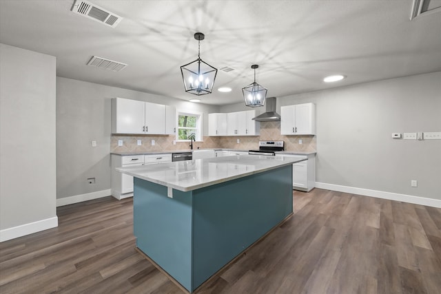 kitchen featuring a kitchen island, decorative light fixtures, white cabinetry, appliances with stainless steel finishes, and dark hardwood / wood-style floors