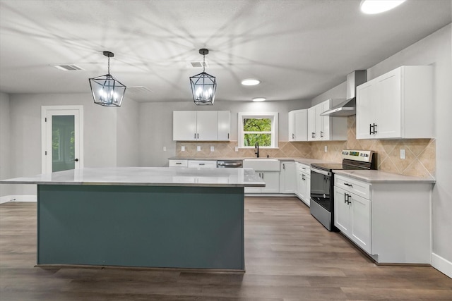 kitchen with appliances with stainless steel finishes, visible vents, white cabinets, and wall chimney exhaust hood