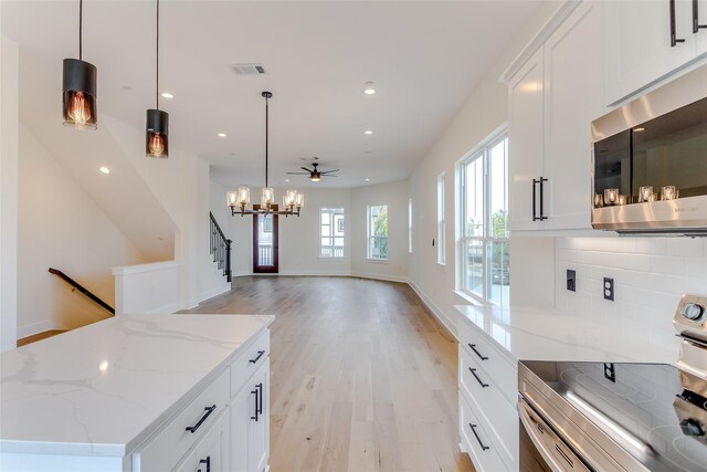 kitchen featuring light wood finished floors, visible vents, decorative backsplash, stainless steel appliances, and white cabinetry