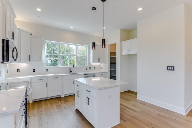 kitchen featuring tasteful backsplash, stainless steel appliances, a sink, and light wood-style flooring