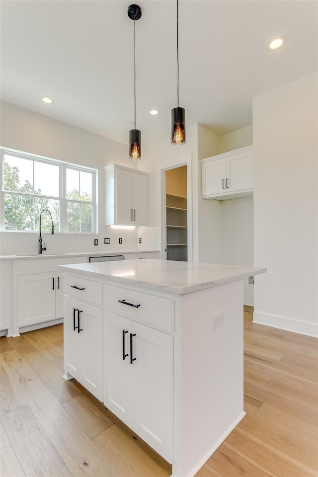 kitchen featuring recessed lighting, light wood-type flooring, white cabinets, and a center island