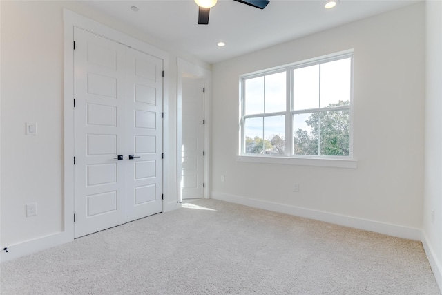 unfurnished bedroom with carpet, a closet, baseboards, and recessed lighting