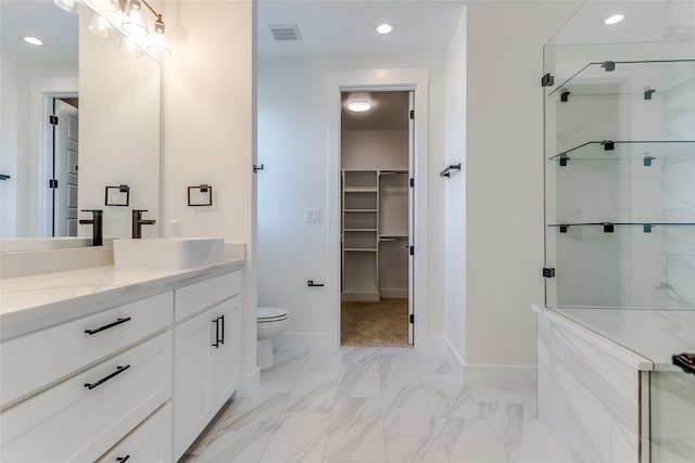 bathroom featuring a shower with shower door, marble finish floor, visible vents, and a walk in closet