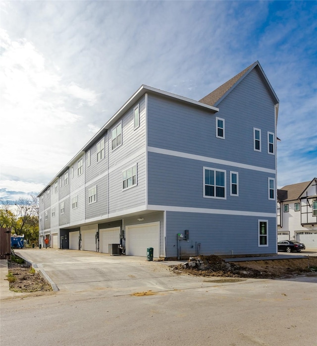 view of home's exterior with cooling unit and an attached garage