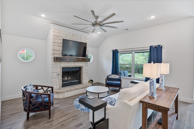 living room with hardwood / wood-style flooring, ceiling fan, a fireplace, and vaulted ceiling