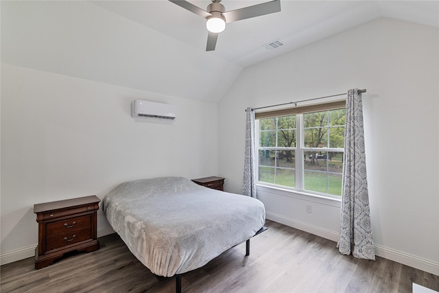 bedroom with lofted ceiling, hardwood / wood-style floors, an AC wall unit, and ceiling fan