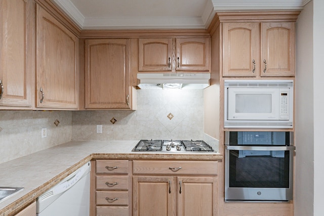 kitchen with ornamental molding, backsplash, stainless steel appliances, tile counters, and light brown cabinetry