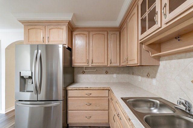 kitchen featuring tasteful backsplash, tile counters, light brown cabinetry, stainless steel refrigerator with ice dispenser, and sink