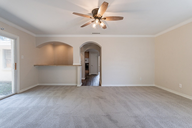 carpeted empty room with ceiling fan and crown molding