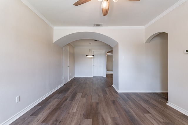 unfurnished room with ornamental molding, ceiling fan, and dark wood-type flooring