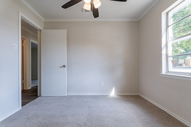 empty room featuring ceiling fan, plenty of natural light, and ornamental molding