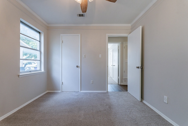 unfurnished bedroom with ornamental molding, ceiling fan, and carpet floors