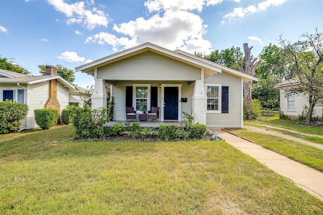 bungalow-style house with a front lawn and covered porch