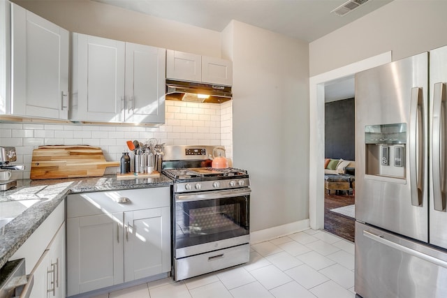 kitchen with stainless steel appliances, white cabinetry, light tile patterned floors, and tasteful backsplash