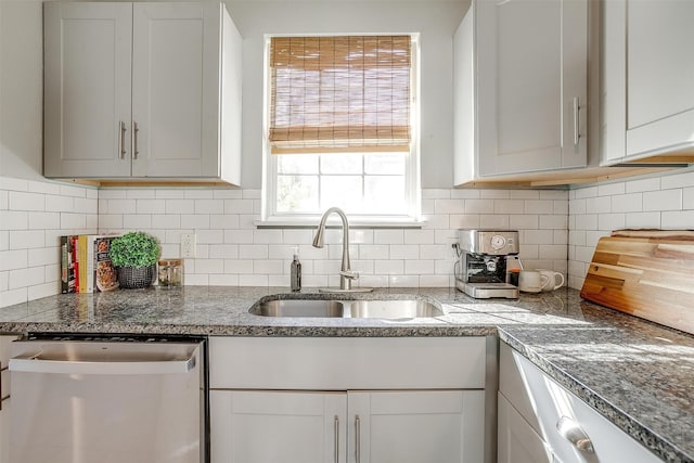 kitchen with backsplash, white cabinetry, sink, and stainless steel dishwasher