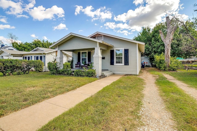 bungalow-style house featuring covered porch and a front yard