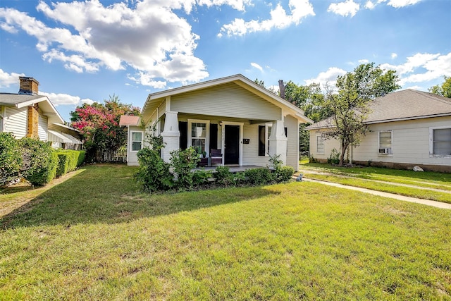 bungalow-style house with a front yard and covered porch