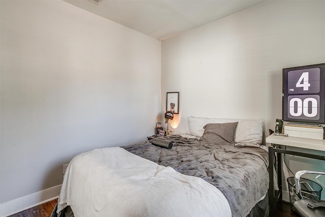 bedroom with dark hardwood / wood-style flooring