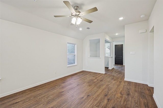 empty room with ceiling fan, lofted ceiling, and dark hardwood / wood-style flooring