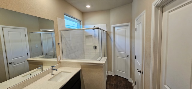 bathroom with walk in shower, vanity, and hardwood / wood-style floors