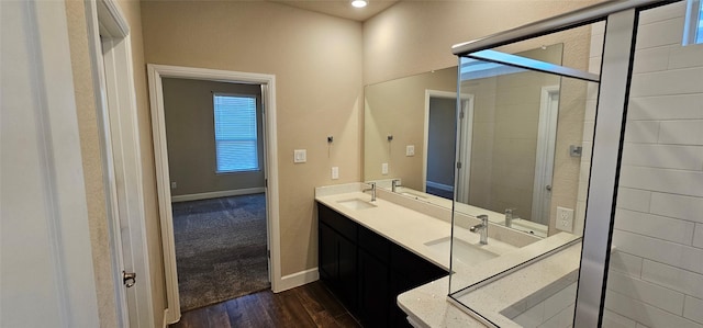 bathroom with hardwood / wood-style flooring, vanity, and a shower with door