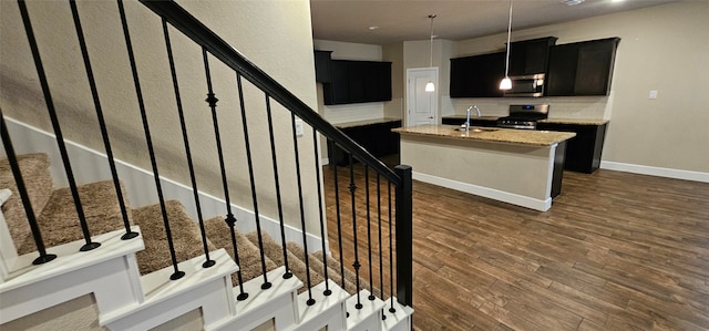 staircase featuring sink and wood-type flooring