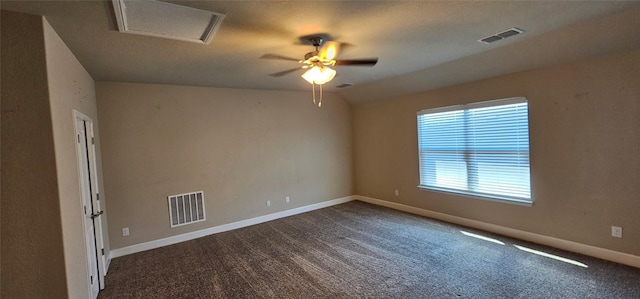 empty room featuring vaulted ceiling, ceiling fan, and dark carpet