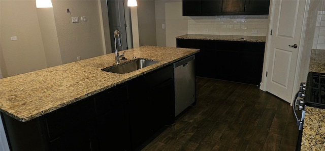 kitchen featuring sink, dark hardwood / wood-style flooring, a kitchen island with sink, stainless steel dishwasher, and light stone counters