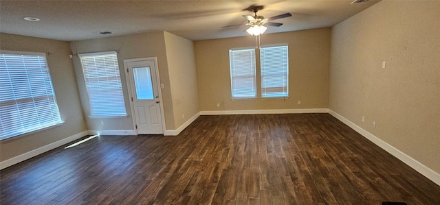 empty room with dark hardwood / wood-style floors and ceiling fan