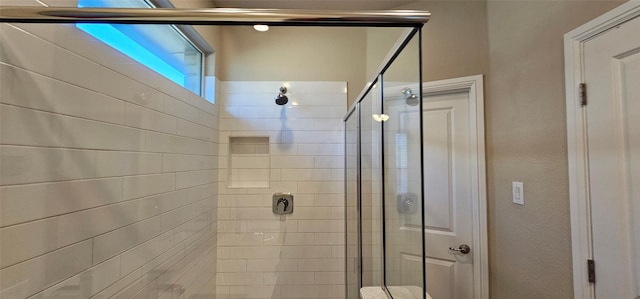 bathroom featuring a shower with shower door