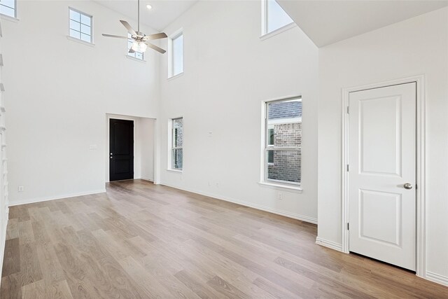 3913 Sky Dr, Sherman, TX 75090 - unfurnished living room featuring a high ceiling, plenty of natural light, ceiling fan, and light wood-style flooring