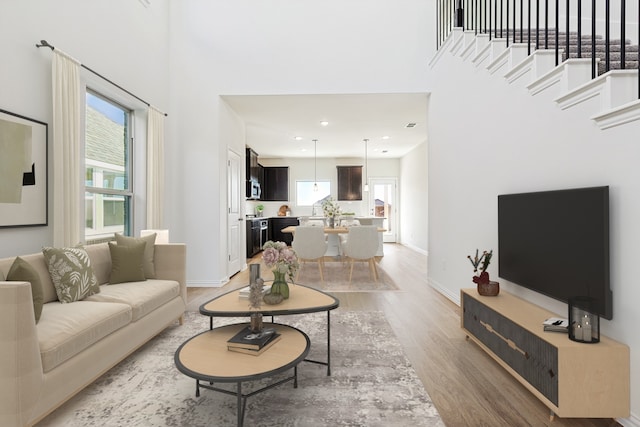 3913 Sky Dr, Sherman, TX 75090 - living room featuring light wood-style floors, a high ceiling, baseboards, and recessed lighting
