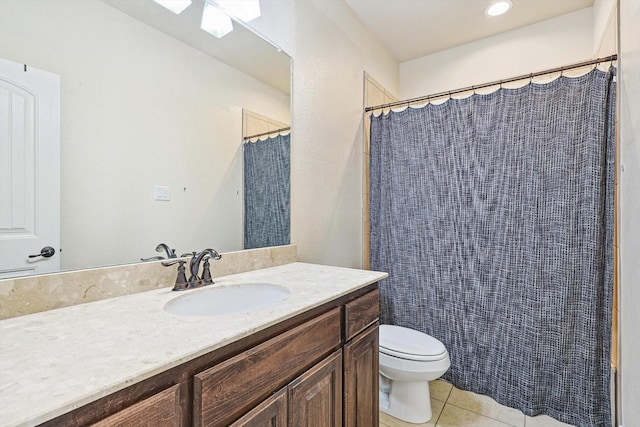 bathroom with toilet, vanity, and tile patterned floors