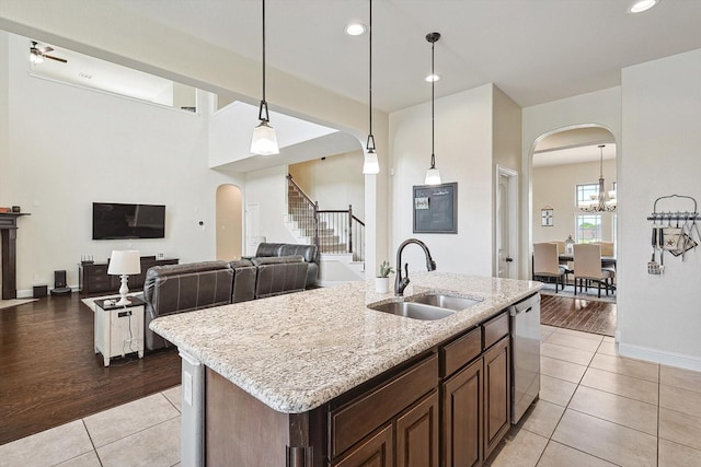 kitchen with sink, hanging light fixtures, stainless steel dishwasher, and light tile patterned floors