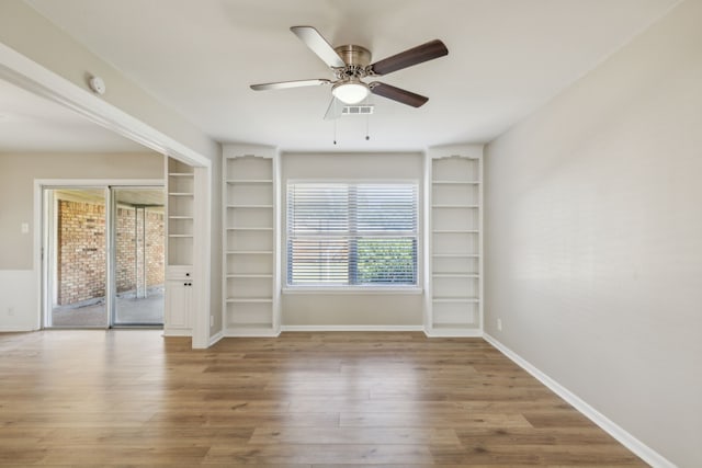 spare room featuring a healthy amount of sunlight, light hardwood / wood-style floors, and ceiling fan