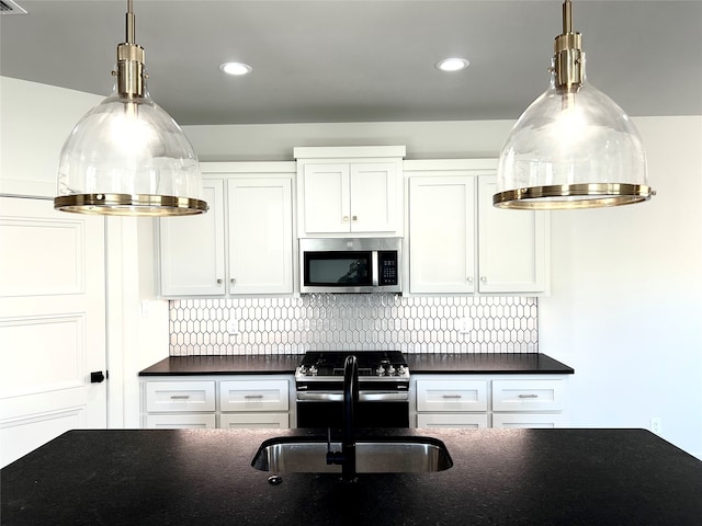 kitchen with white cabinets, stainless steel appliances, sink, and tasteful backsplash