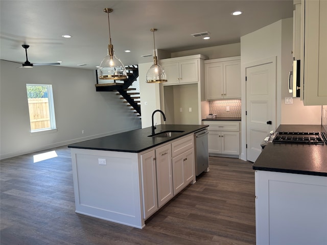 kitchen with stainless steel appliances, white cabinets, decorative light fixtures, and sink